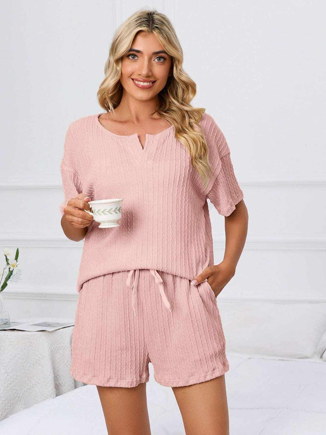 Women's notched short sleeve and shorts lounge set in pink, slightly stretchy polyester blend.