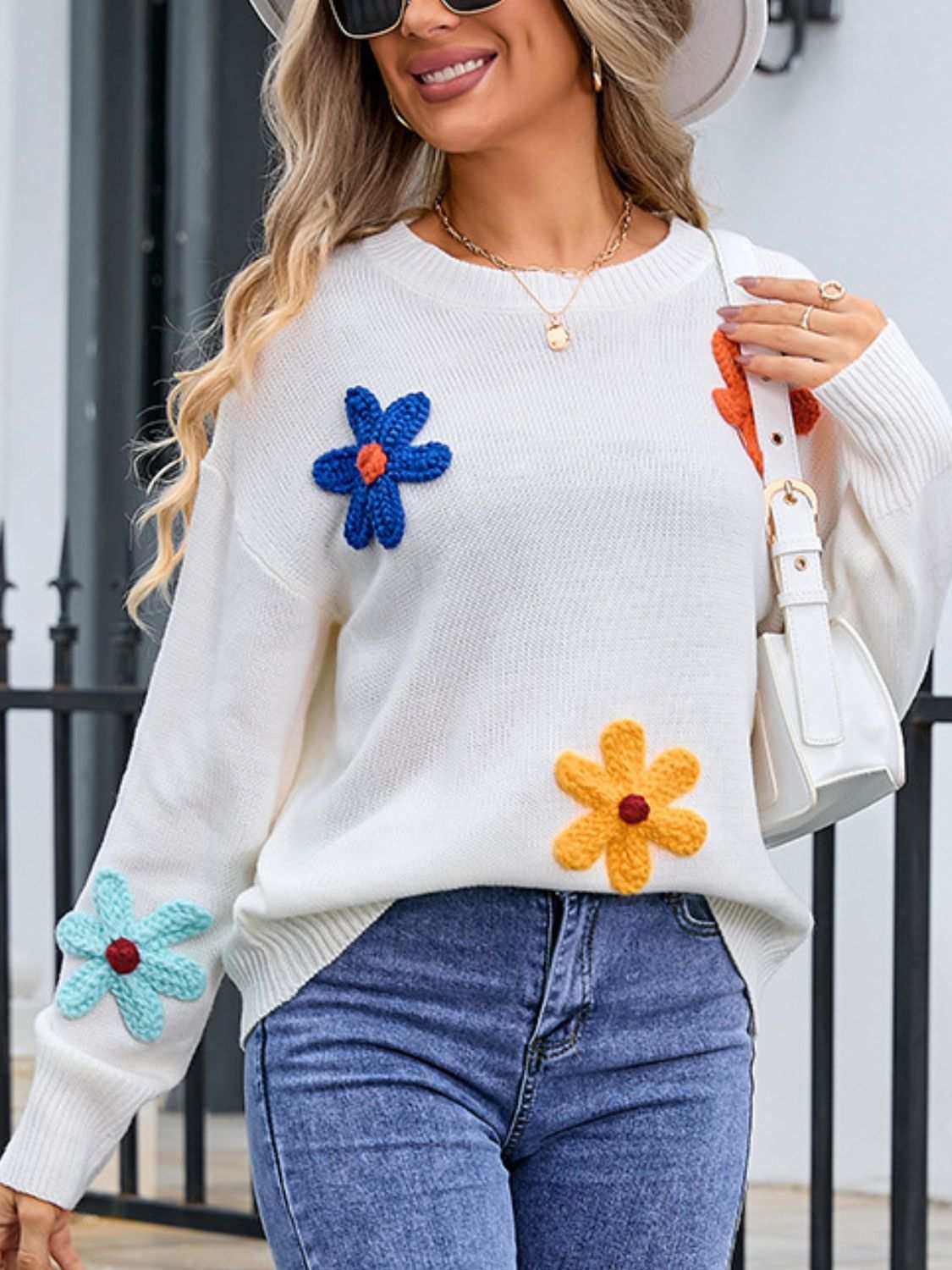 Woman wearing Angel Wings Crochet Flower Round Neck Sweater with colorful floral accents.