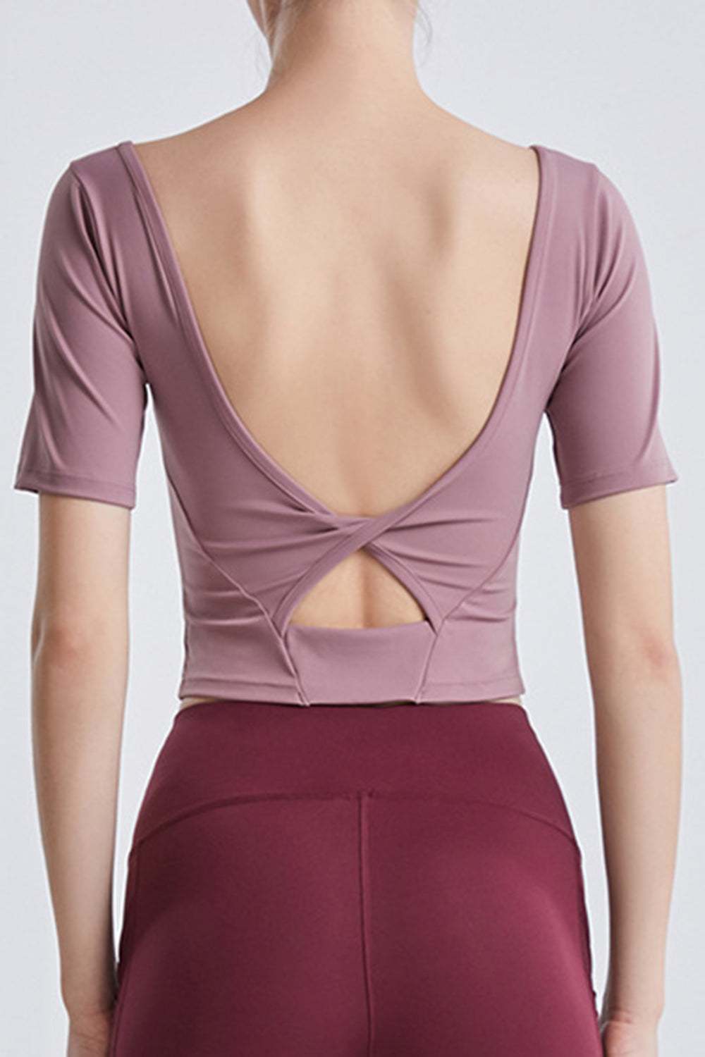 Back view of a mauve cutout backless round neck active T-shirt.