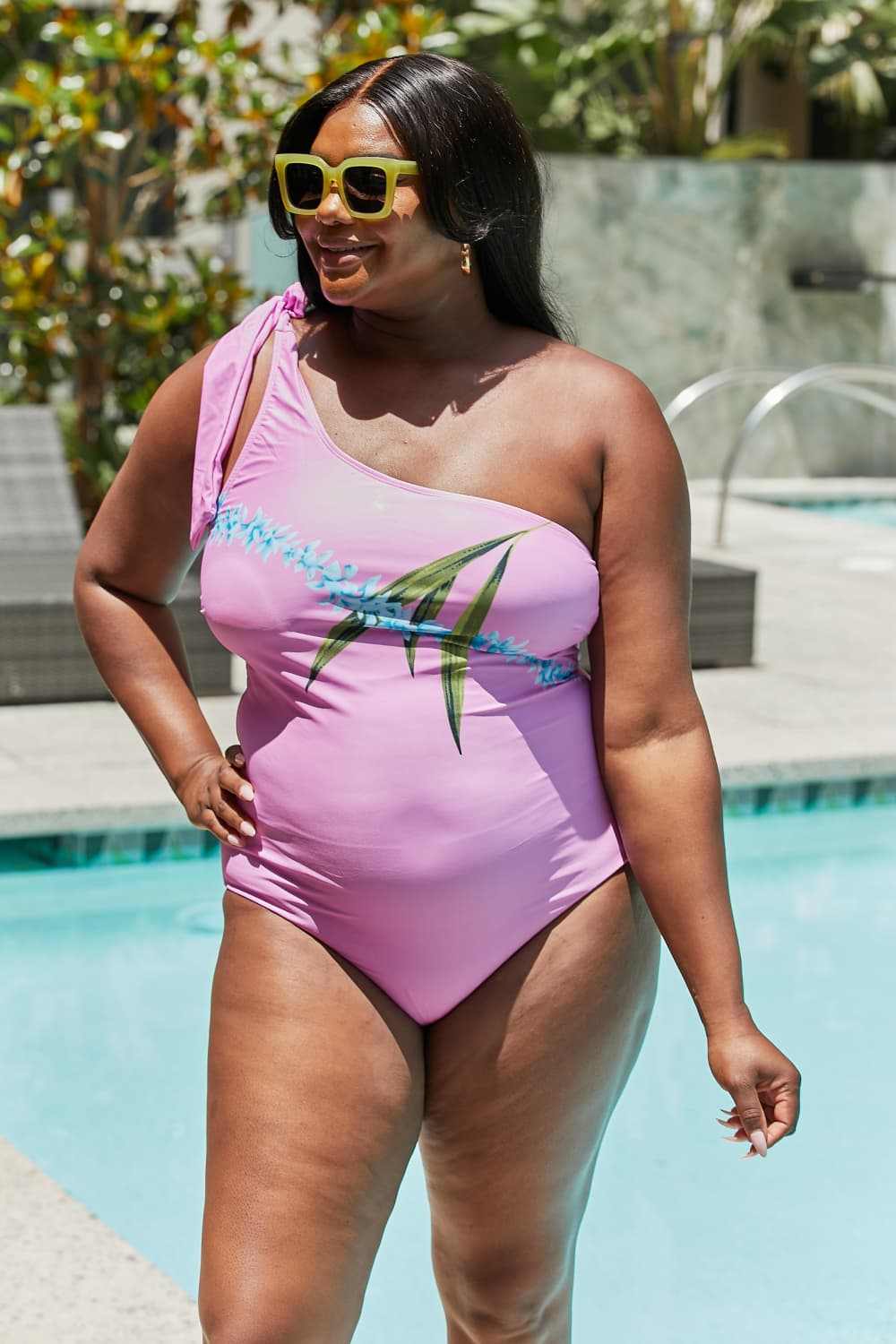 Marina West Swim Vacay Mode one-shoulder swimsuit in carnation pink by the pool, featuring asymmetrical neckline and tie detail.