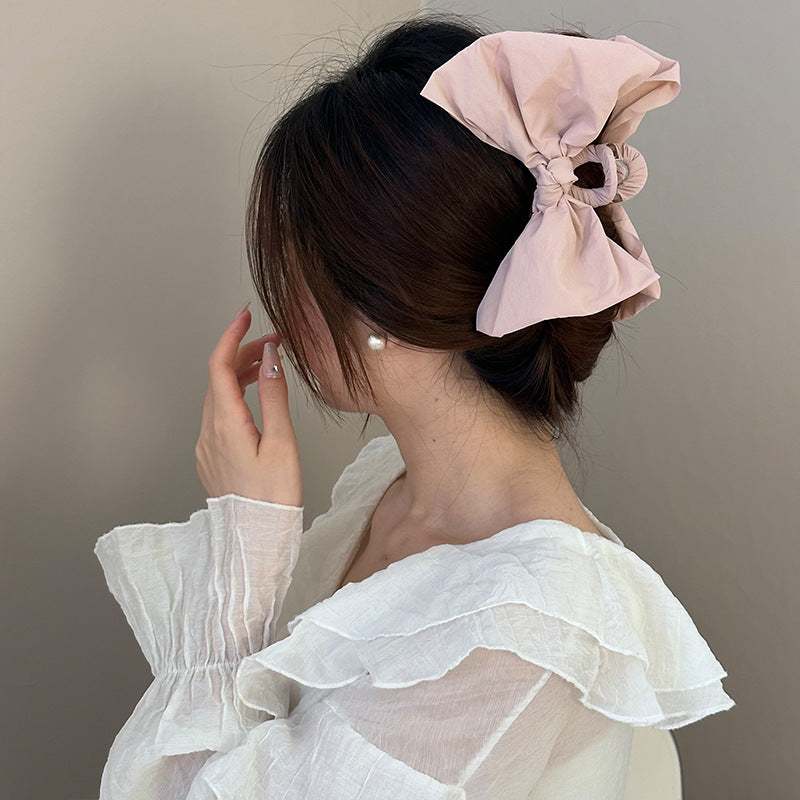 Pink polyester bow hair claw clip on woman's hair, length 5.1 inches.