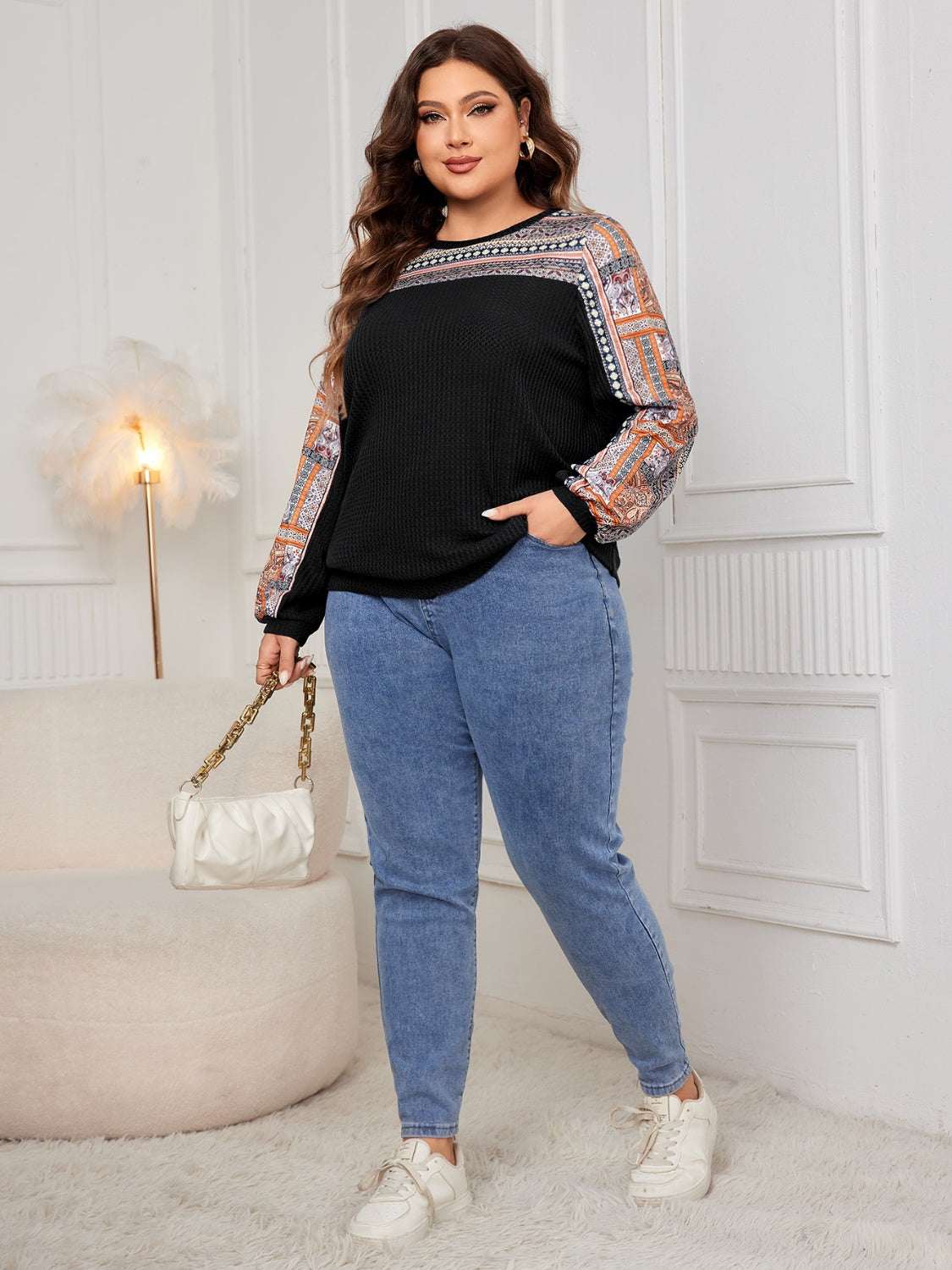 Plus-size woman in a printed long sleeve sweatshirt and jeans.