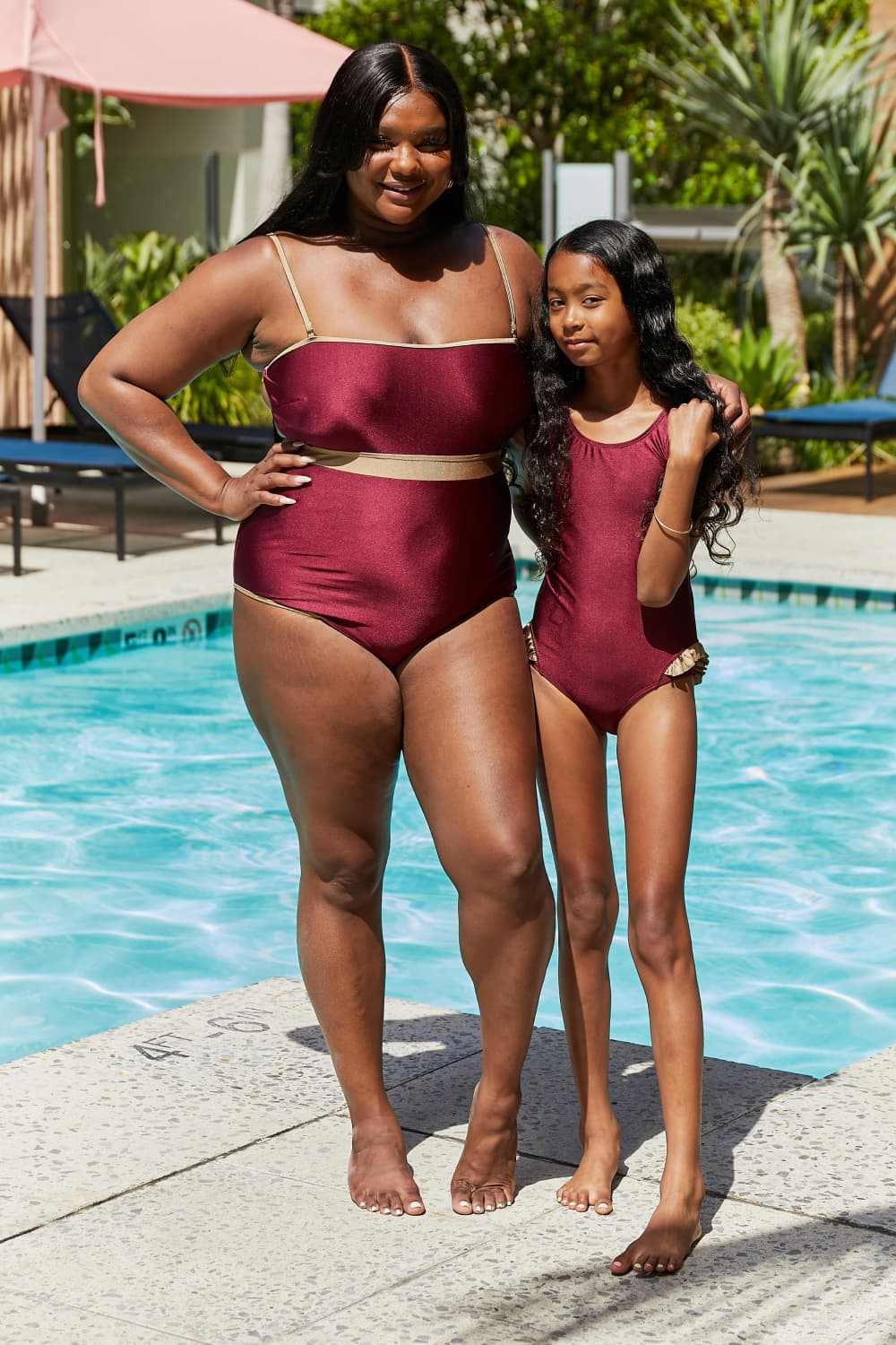 Marina West Swim Wave Break Contrast Trim one-piece swimsuit in wine with open-back design by poolside.