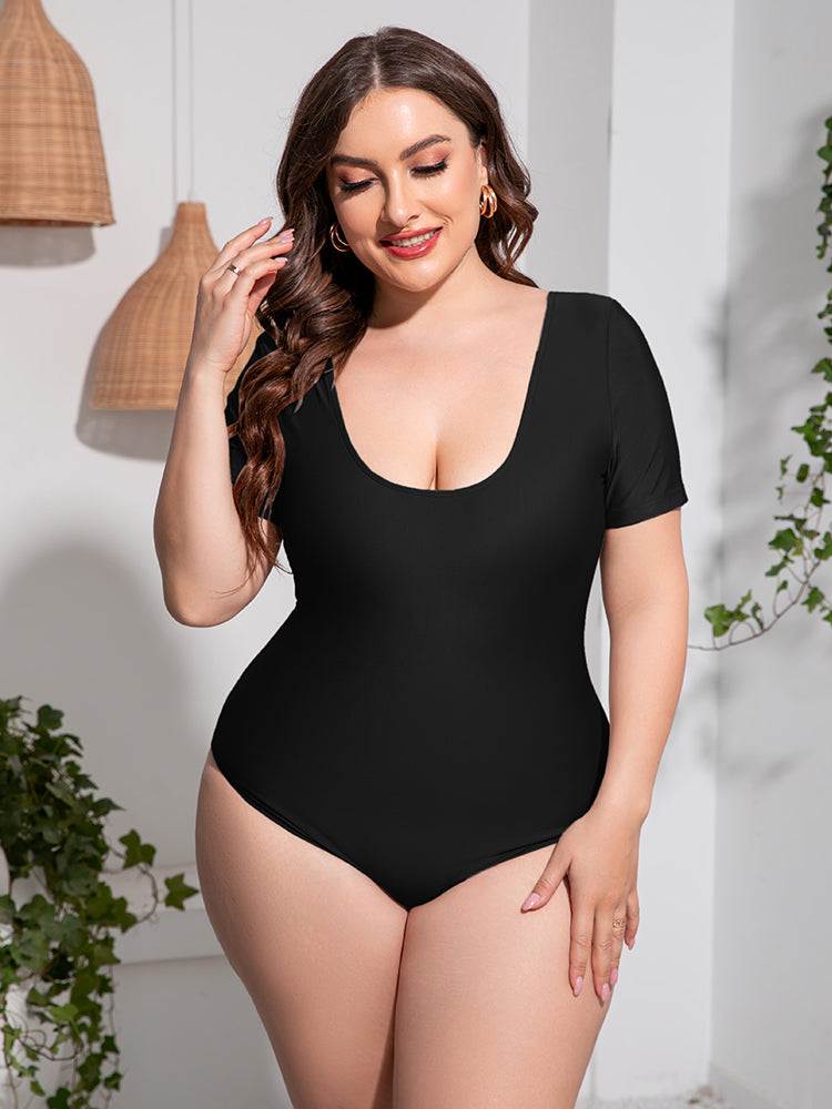 Plus size one-piece swimsuit with scoop neck and short sleeves in solid color.