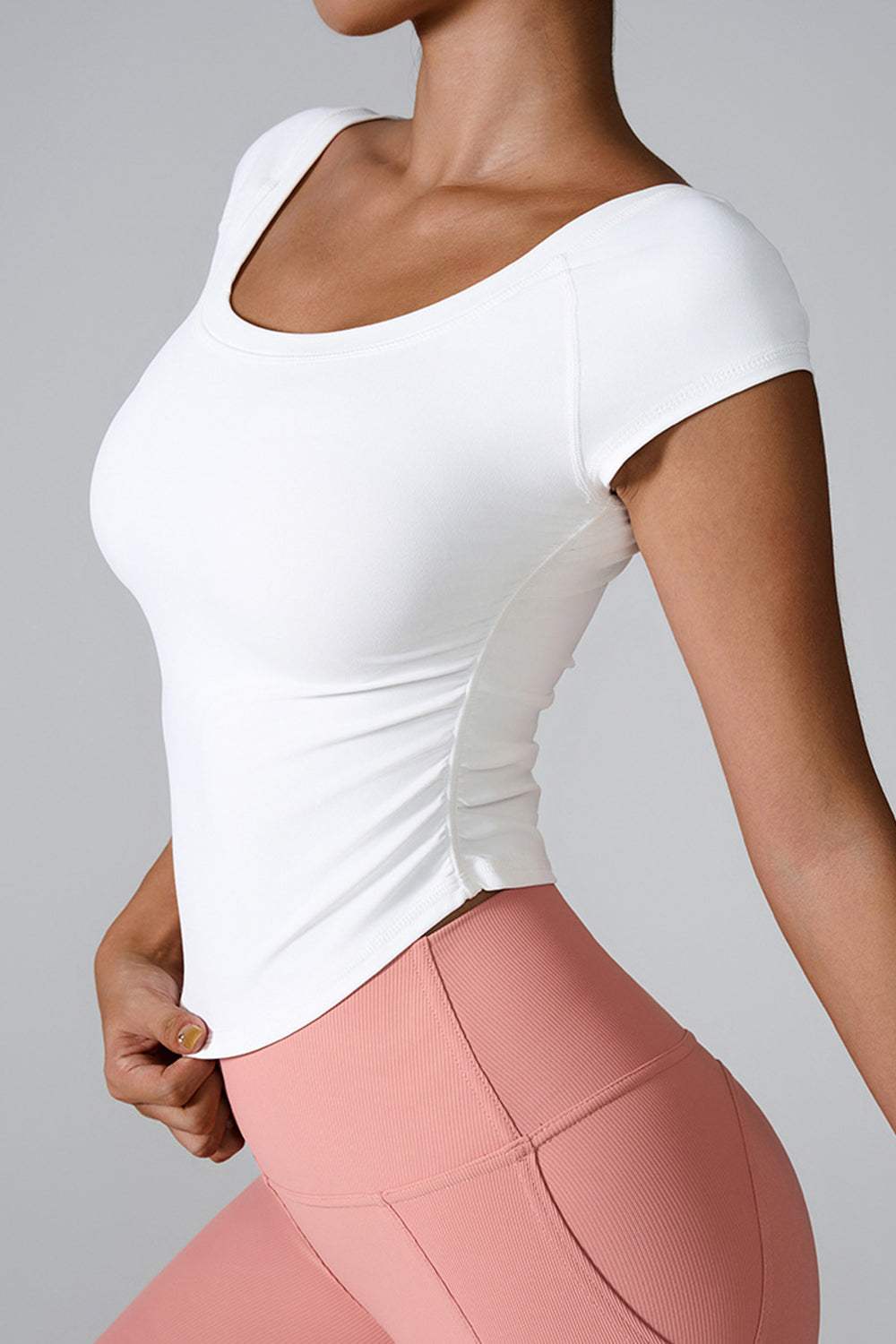 Woman wearing a white round neck short sleeve active T-shirt with a smooth fit.