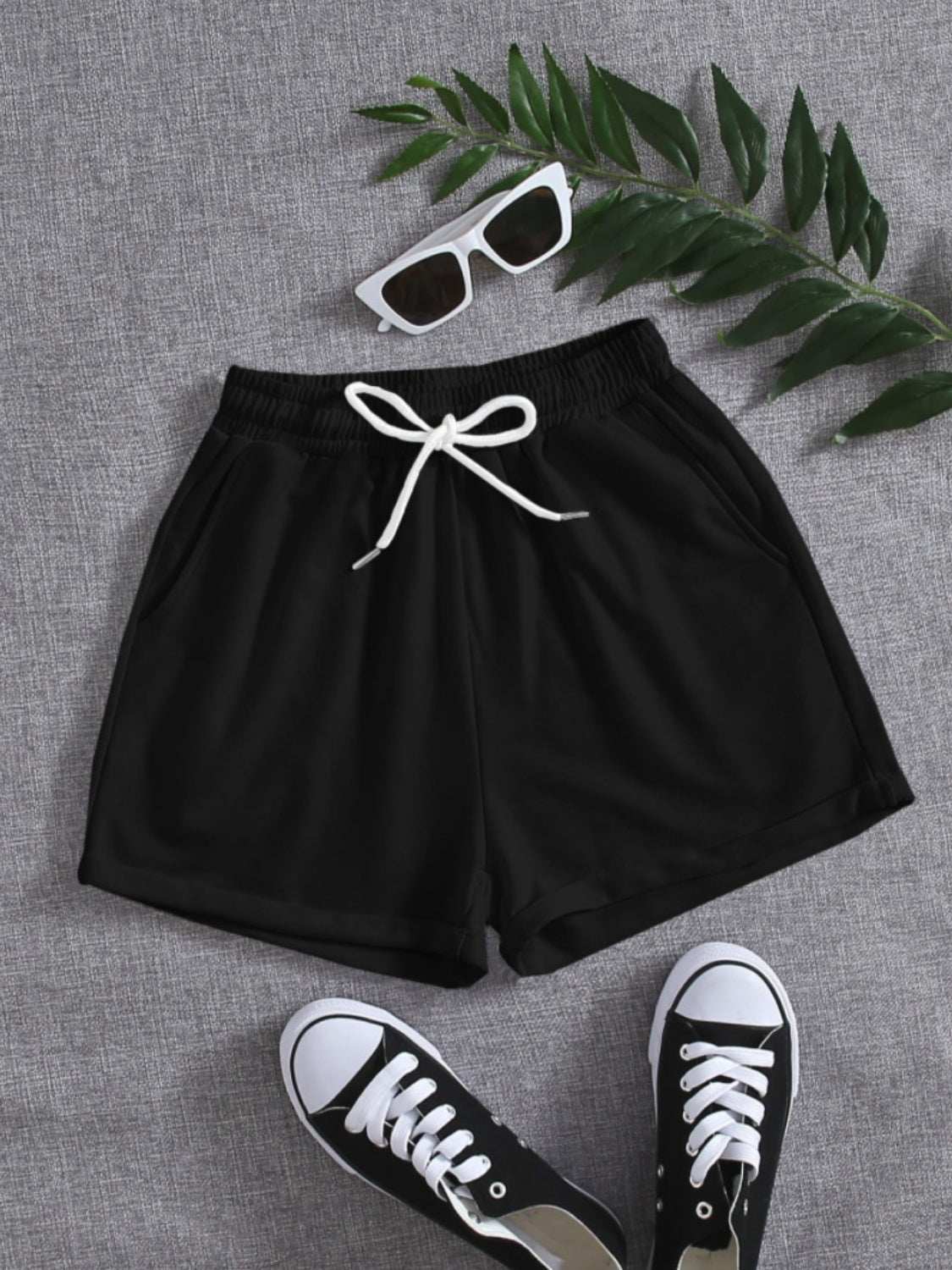 Black drawstring pocketed elastic waist shorts made from 100% polyester.