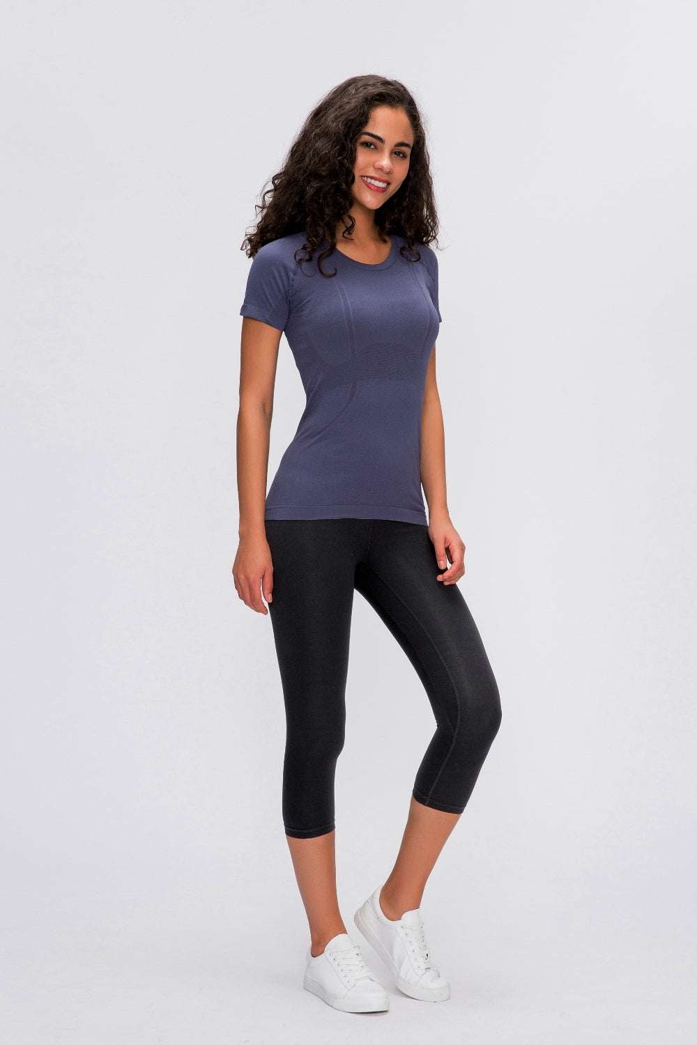 Millennia Round Neck Short Sleeve Active T-Shirt in navy, shown on a woman with black leggings.