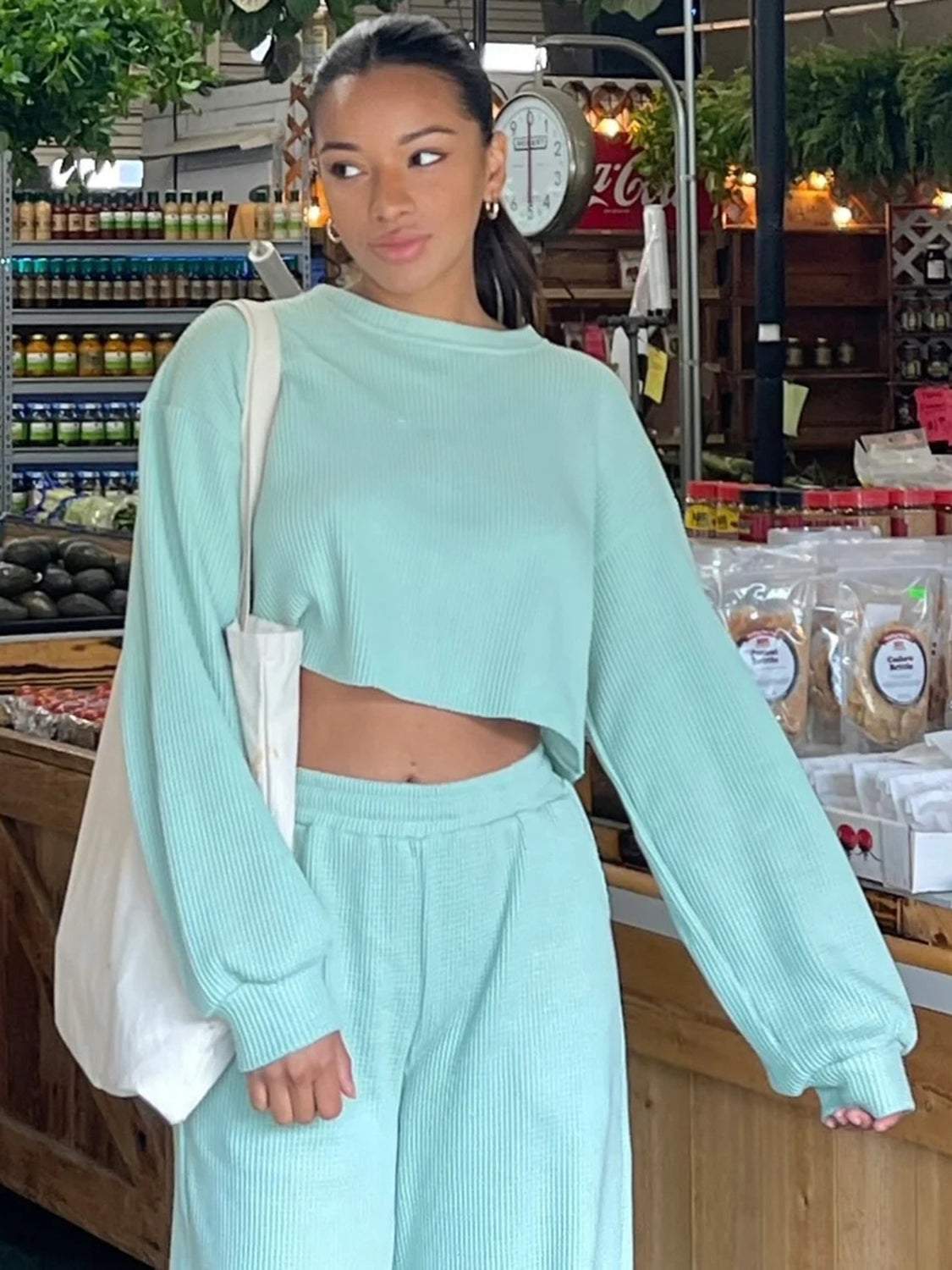 Woman wearing a light blue waffle-knit round neck top and pants set.