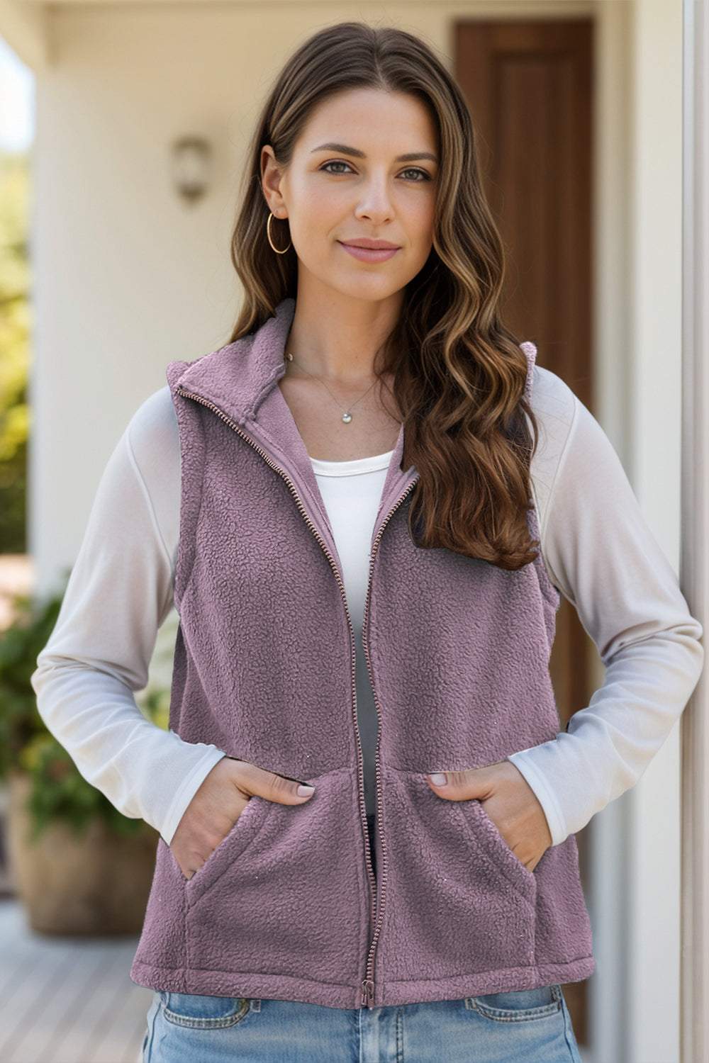 Woman wearing a zip-up vest coat with pockets made of polyester and spandex.