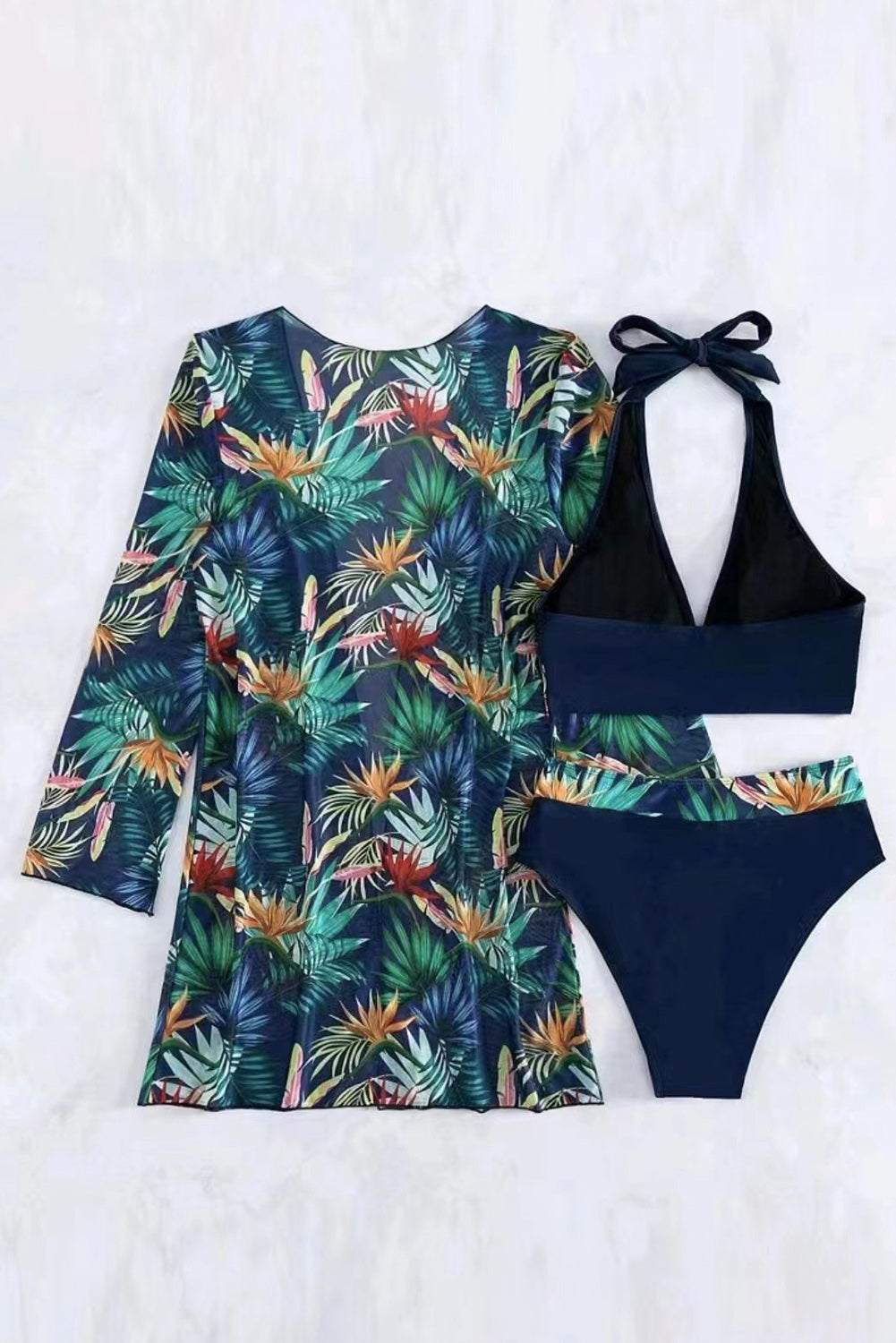 Printed halter neck three-piece swim set with tropical design and removable padding.