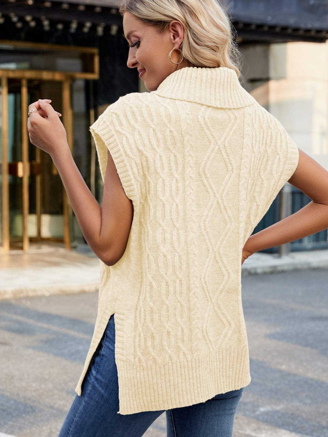 Side slit turtleneck sweater vest in light beige, featuring a cable-knit pattern and sleeveless design.