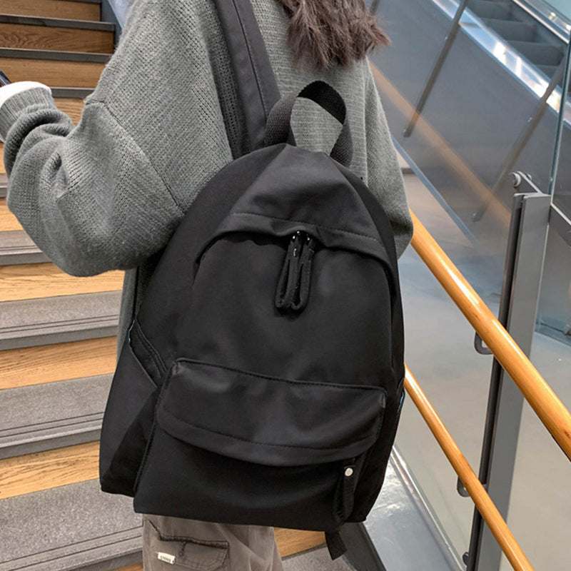 Large cotton zip backpack on person, black color, ideal for travel.