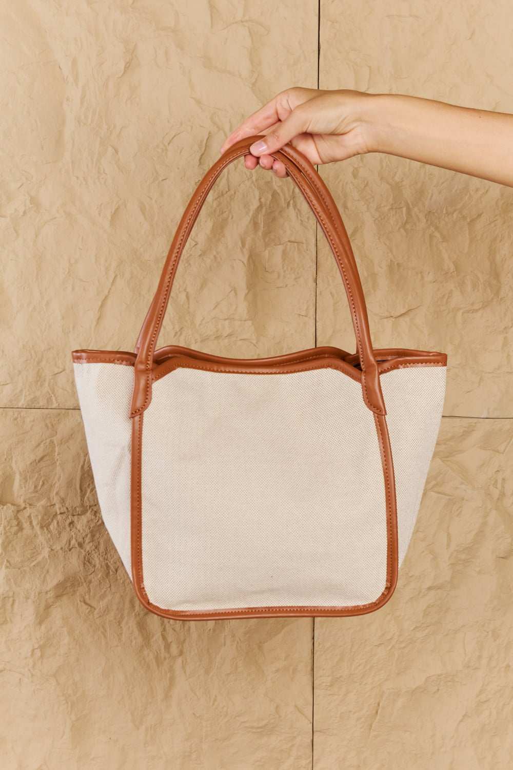 Ochre tote bag with faux leather trim, spacious interior, and adjustable shoulder strap.