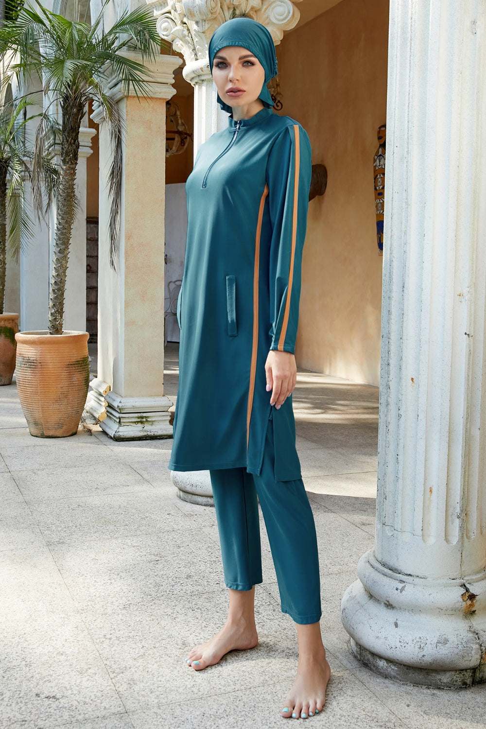 Three-piece swim set with cap, quarter zip top, and pants in teal, featuring highly stretchy polyester-spandex blend.