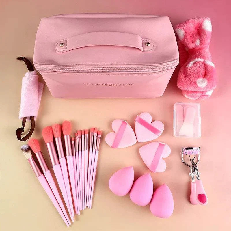 27-piece pink makeup tool set with brushes, puffs, and a cosmetic bag for travel and daily use.