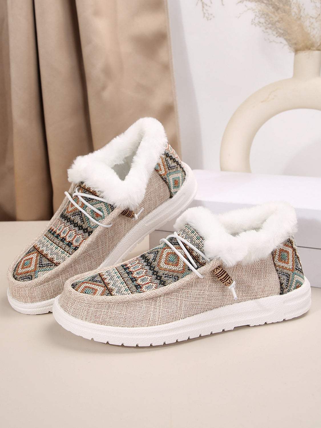 Printed round toe flat slip-ons with faux fur lining and patterned design.