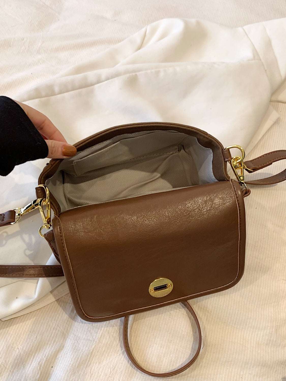 Small PU leather suede twist-lock shoulder bag in brown, open view showing interior.