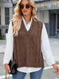 Cable knit V-neck sweater vest in brown, styled over a white shirt.