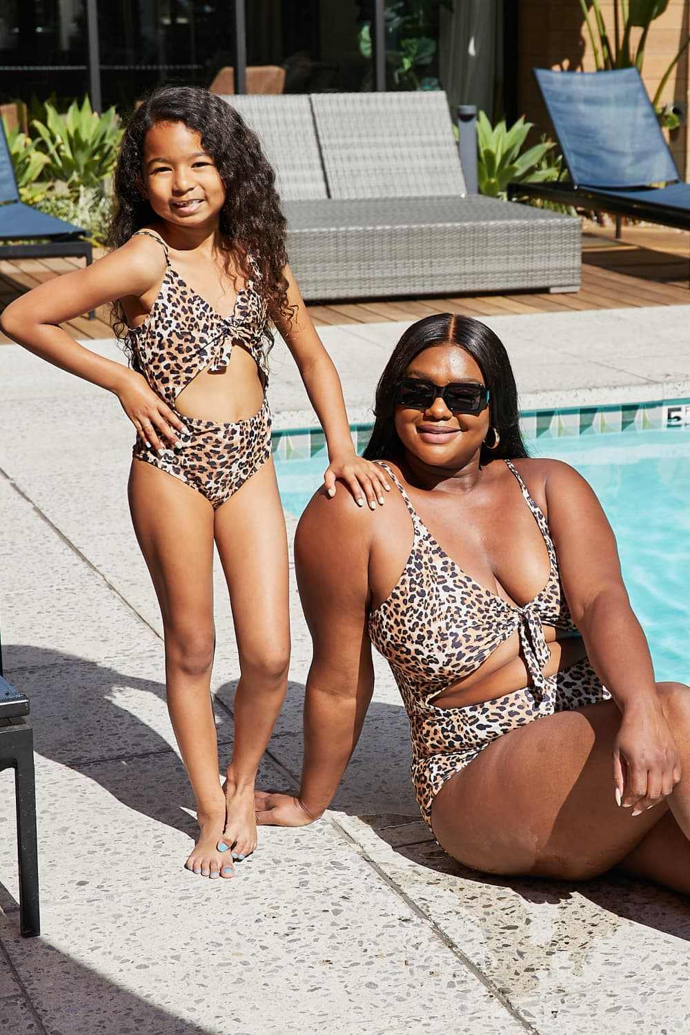 Leopard print cutout one-piece swimsuits at poolside.