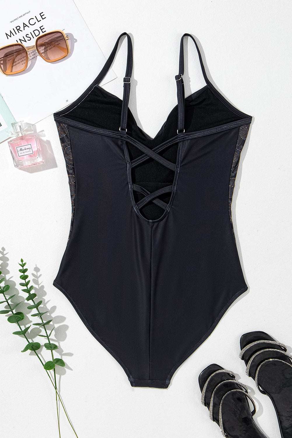 Embroidered V-neck one-piece swimwear with crisscross design and removable padding.