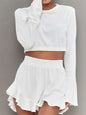 Round neck long sleeve top with ruffled shorts set in white.