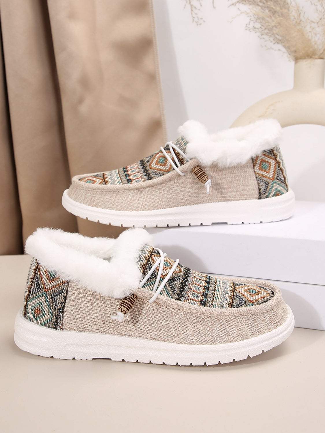 Printed round toe flat slip-ons with faux fur lining and geometric design.