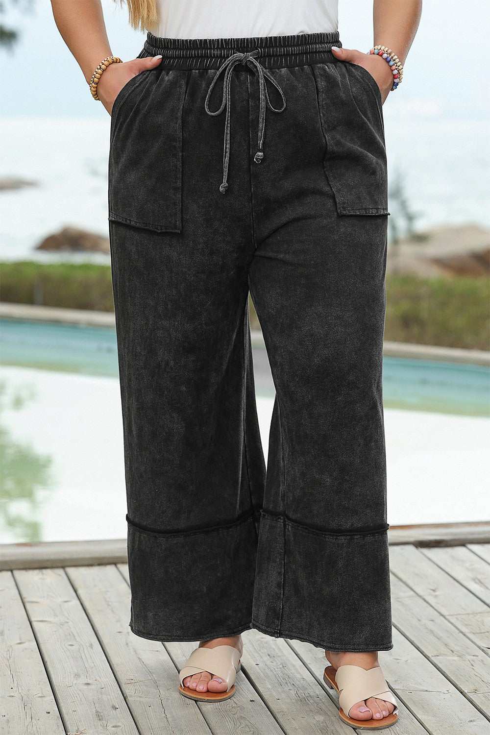 Plus size drawstring wide leg pants in black, 100% cotton, modeled outdoors.