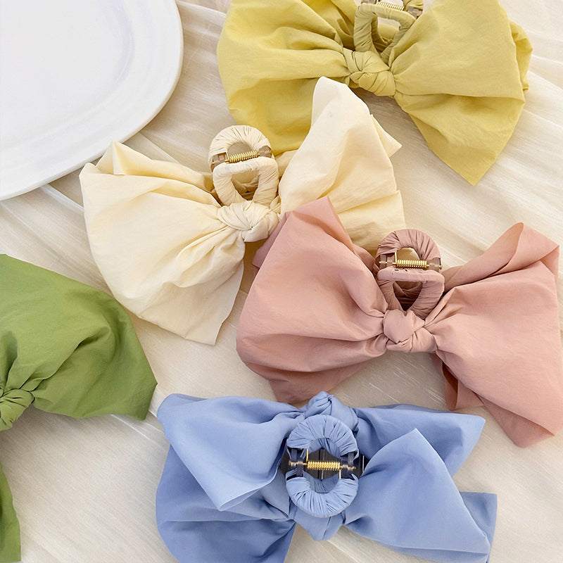 Colorful bow hair claw clips made of polyester with metal detail.