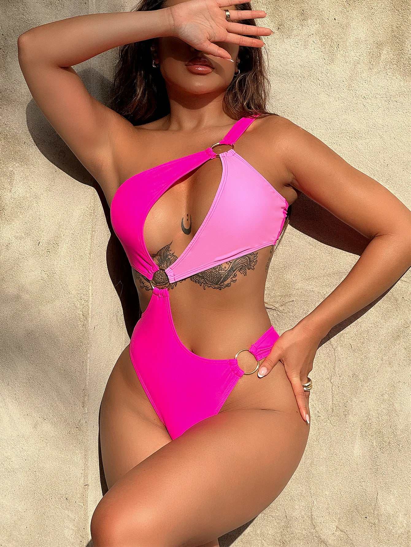 One-shoulder cutout ring detail swimsuit in contrasting pink, sexy beach style.