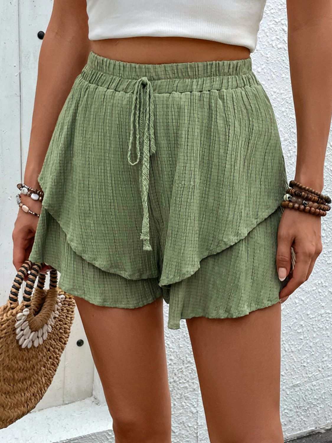 Green high waist layered shorts with tied waist and ruffled design.