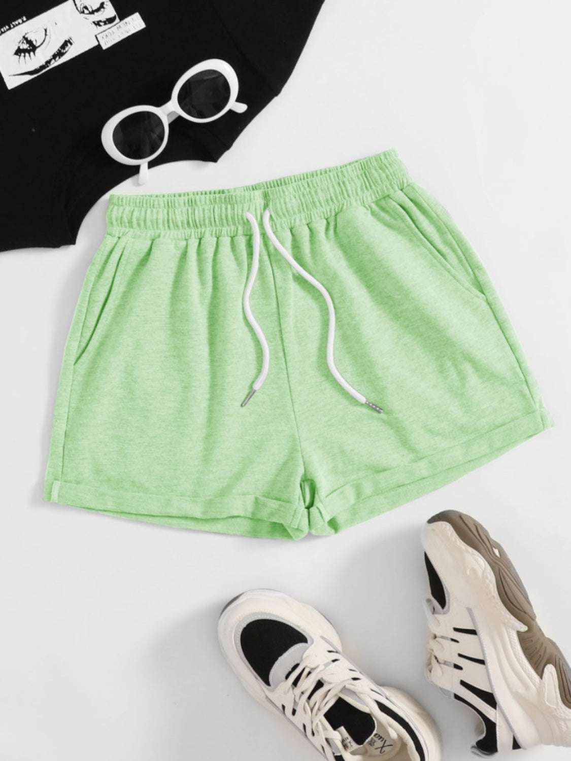 Green drawstring pocketed elastic waist shorts made of polyester.