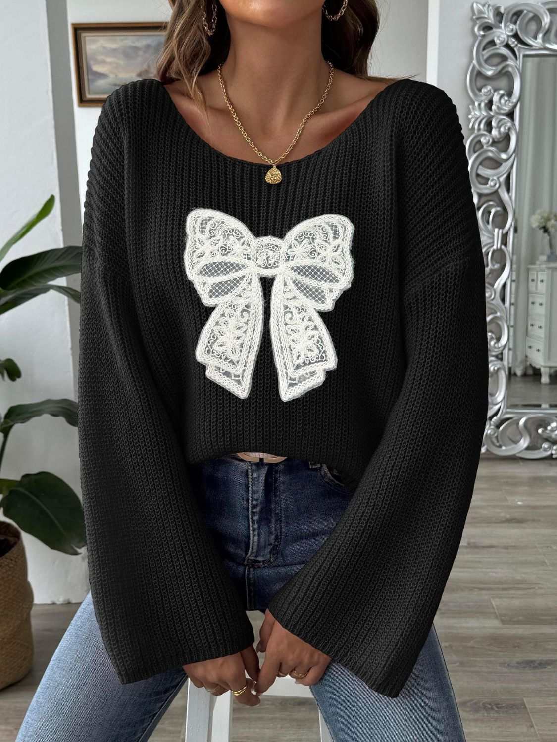 Bow Boat Neck Long Sleeve Sweater in black with a white lace bow design, slightly stretchy, polyester.