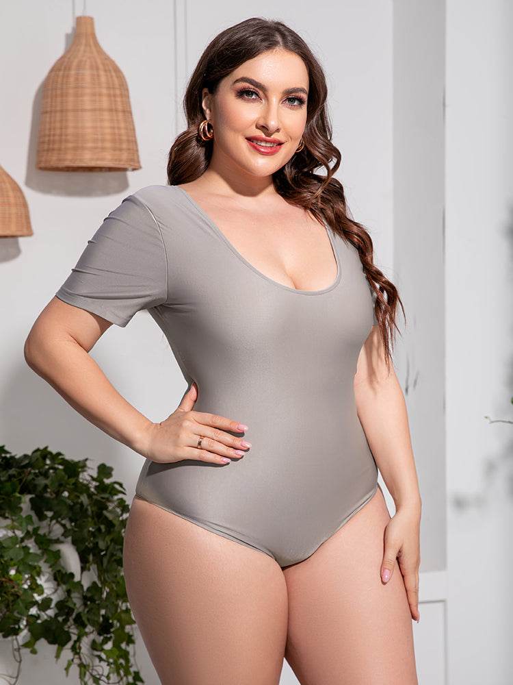 Plus size scoop neck short sleeve one-piece swimsuit in solid color.