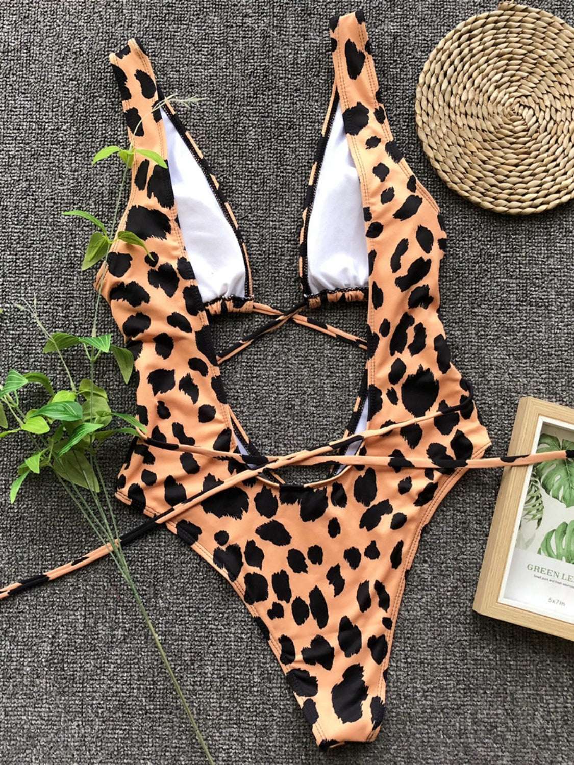 Leopard print lace-up backless plunge one-piece swimwear on display.