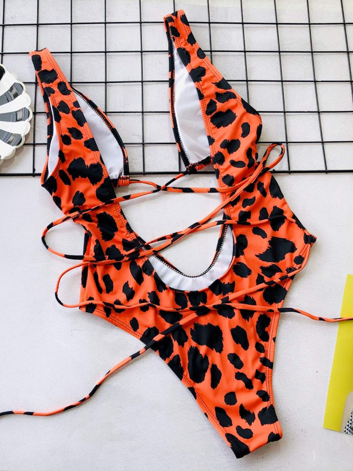 Backless plunge leopard print one-piece swimwear with lace-up design.