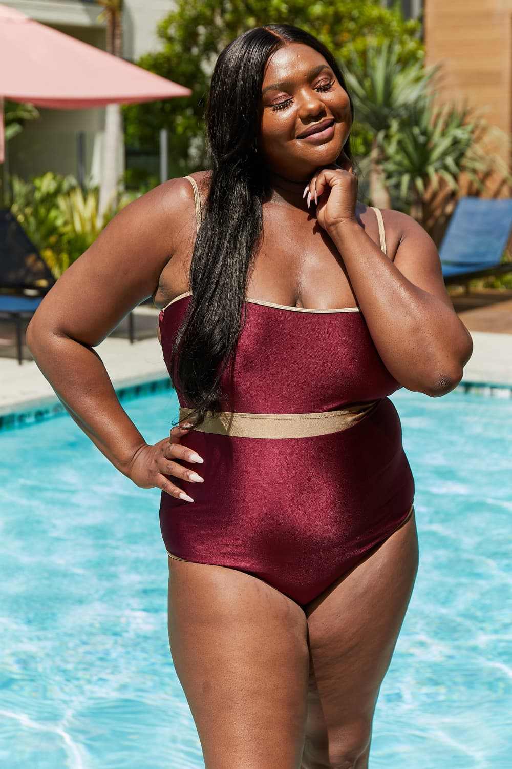 Marina West Swim Wave Break Contrast Trim One-Piece Swimsuit in Wine by the pool.