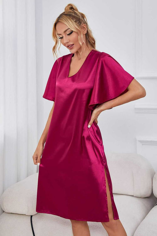 Satin night dress with flutter sleeves, V-neck, and side slit in solid color.