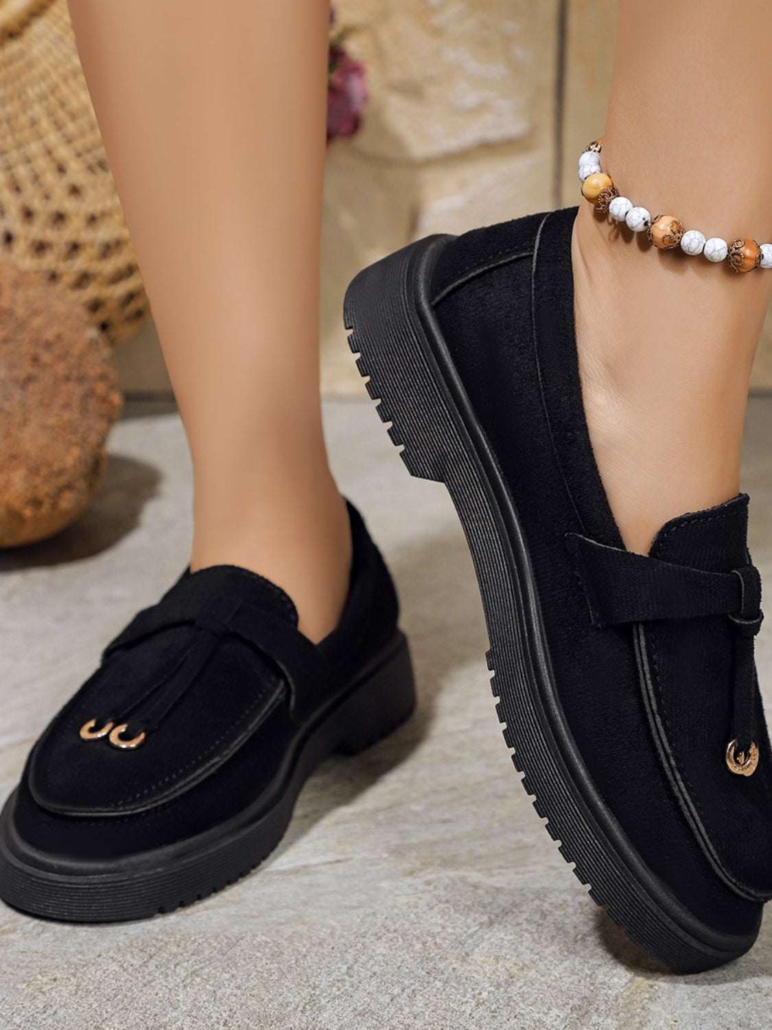 Round toe flat slip-ons made of rubber and polyester, shown in black.