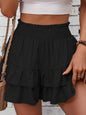 Women's black smocked layered shorts with ruffled design.