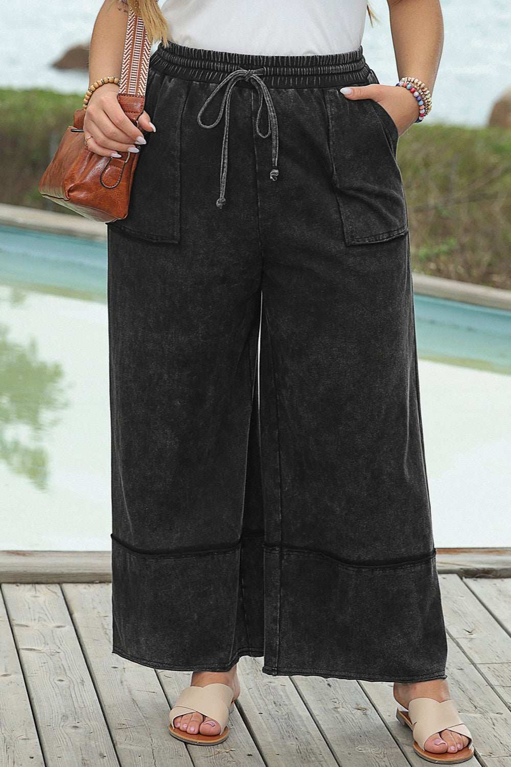 Plus size drawstring wide leg pants in black, 100% cotton, featuring large front pockets.