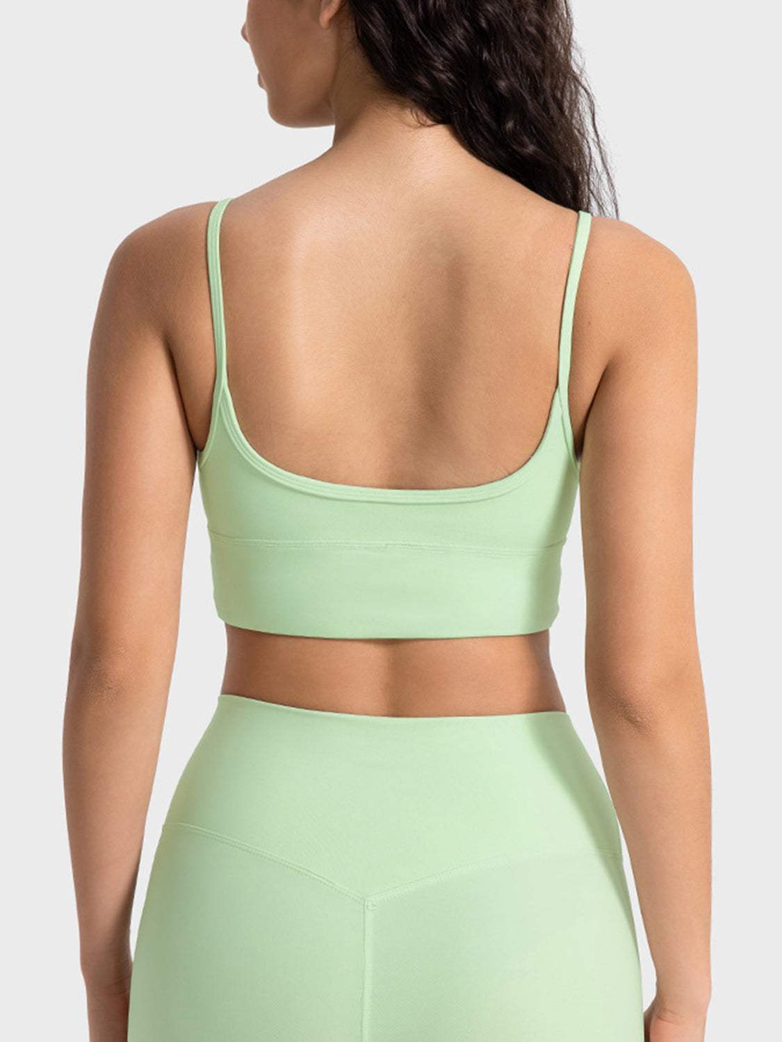 Millennia spaghetti strap sport bra in light green, back view.