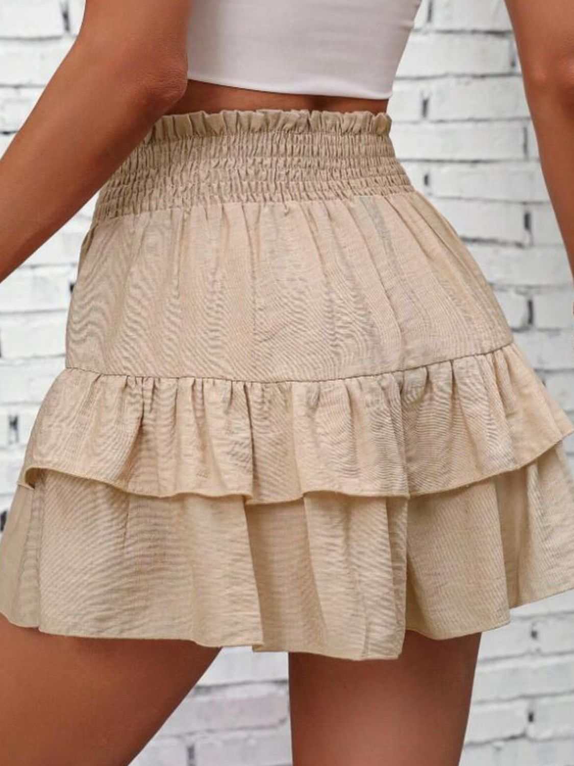 Smocked layered shorts with ruffled design in beige, featuring an opaque polyester material.