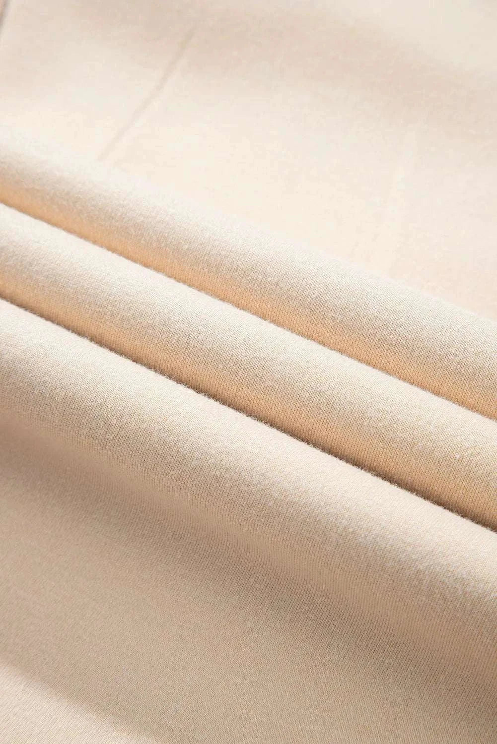 Close-up of beige fabric detail from a plus size color block long sleeve hoodie, polyester and cotton blend.