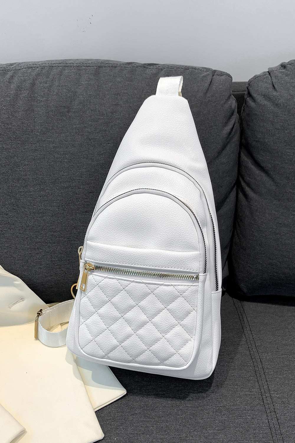 Medium white PU leather sling bag with multiple zip compartments.