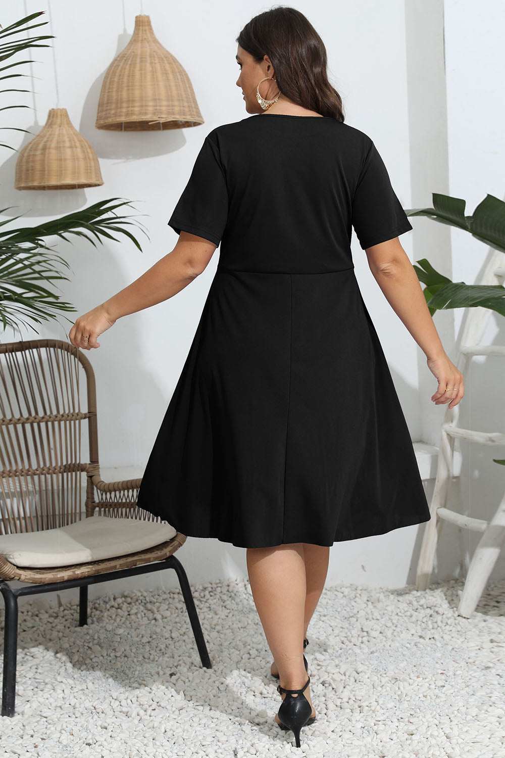 Plus size round neck openwork dress in black, featuring short sleeves and flowing design.