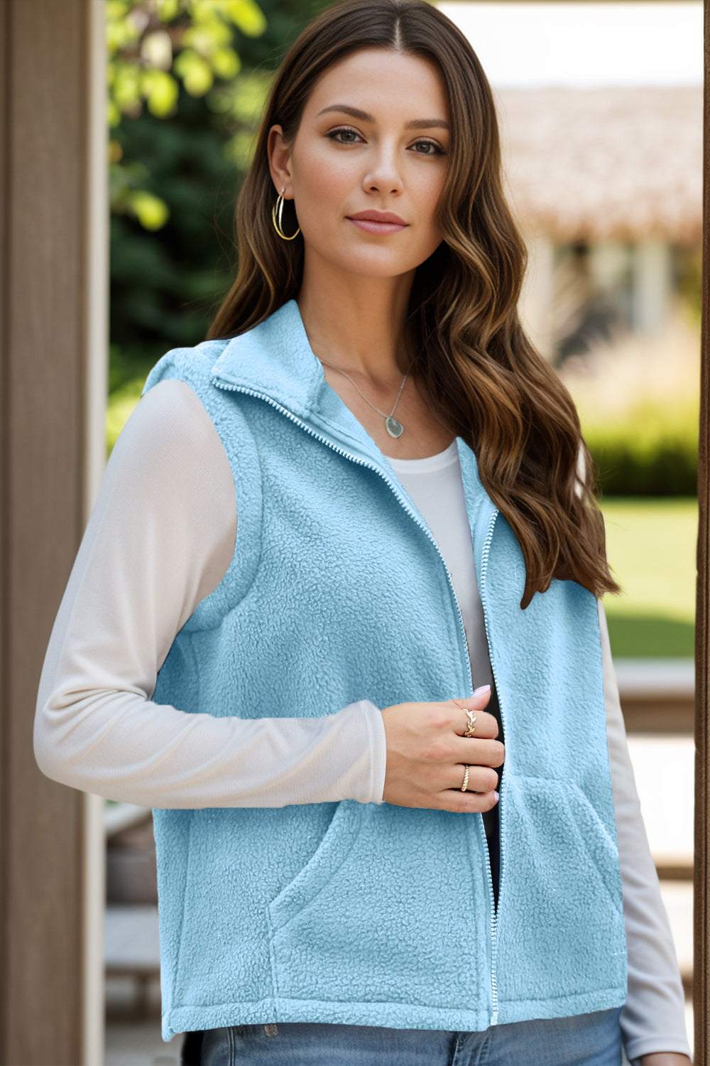 Light blue zip up vest coat with pockets, ideal for layering, made of 95% polyester and 5% spandex.