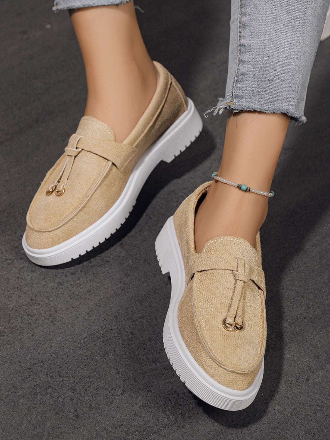 Round toe flat slip-ons in beige with white soles.