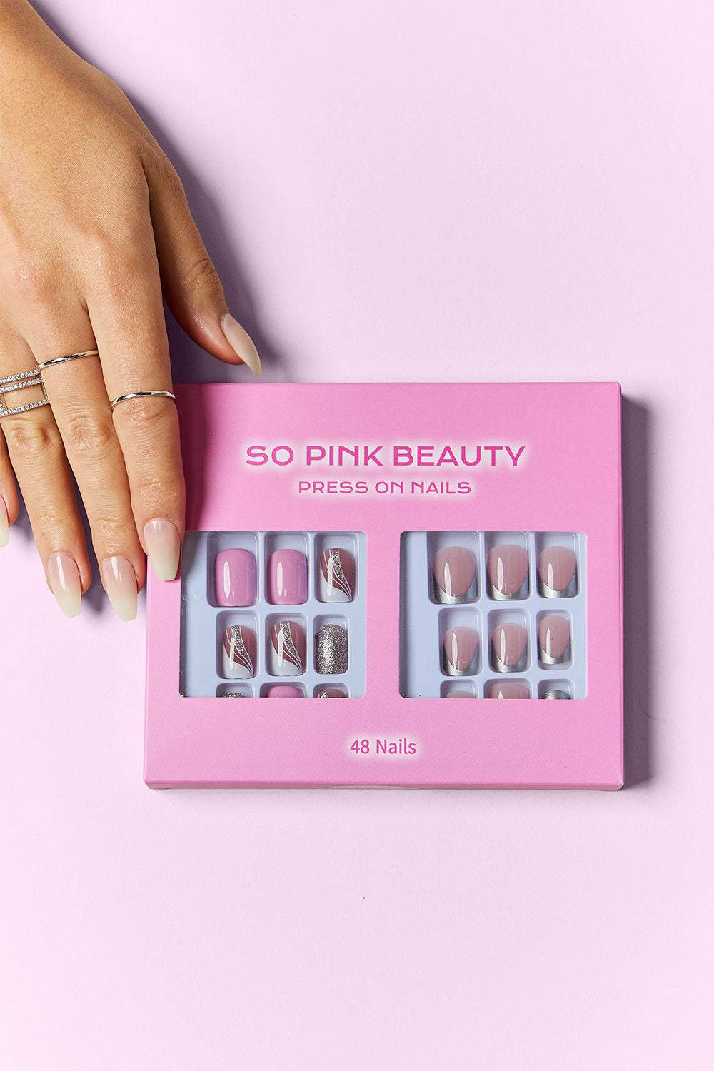 PINK BEAUTY Press On Nails, 48-piece set in pink packaging, showcased with manicured hand, versatile nail designs included.