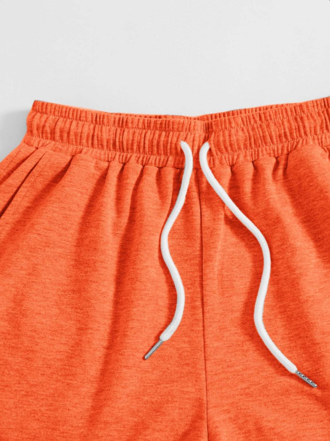 Orange drawstring pocketed elastic waist shorts made of polyester.