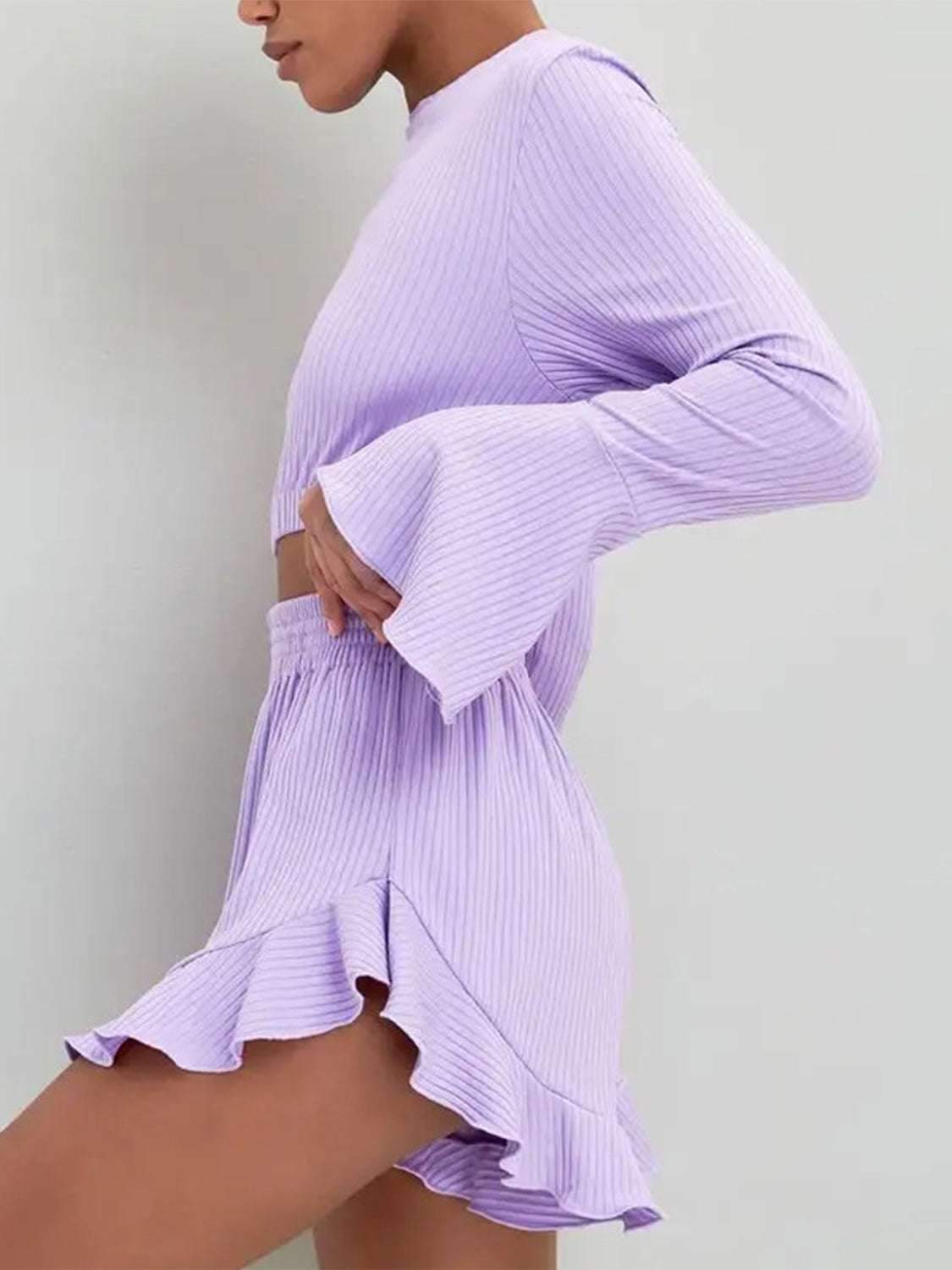 Round neck long sleeve top and ruffled shorts set in purple with peplum design and moderate stretch.